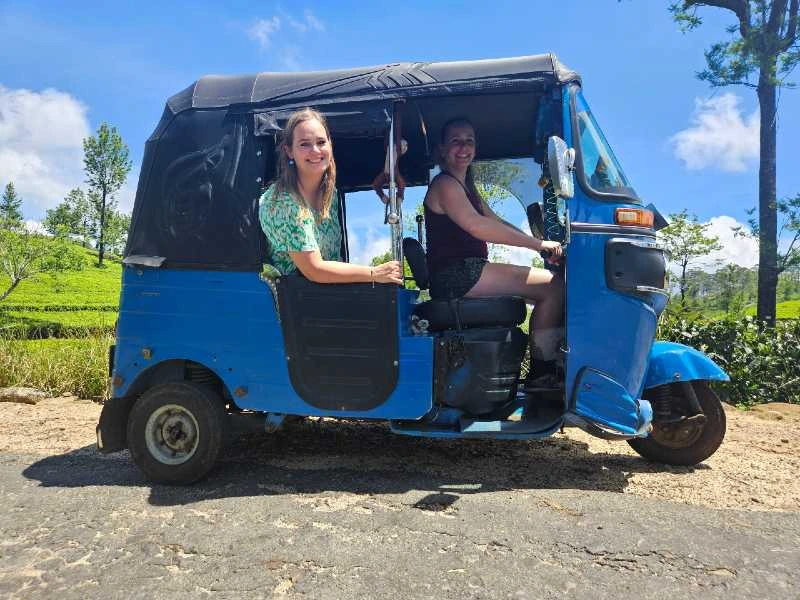 Tourists riding in blue tuk-tuk Sri Lanka - International travelers enjoying authentic three-wheeler ride through countryside scenic route adventure